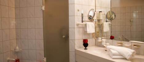 Un baño moderno con bañera, ducha y tocador con espejo.
