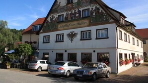 A building with a mural and the text "Gästehaus zum Adler" on the facade.