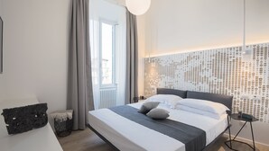 A modern hotel room with a large bed, a bedside table, a small side table, and a decorative wall panel. - Numa Roma GuestHouse (Rome)