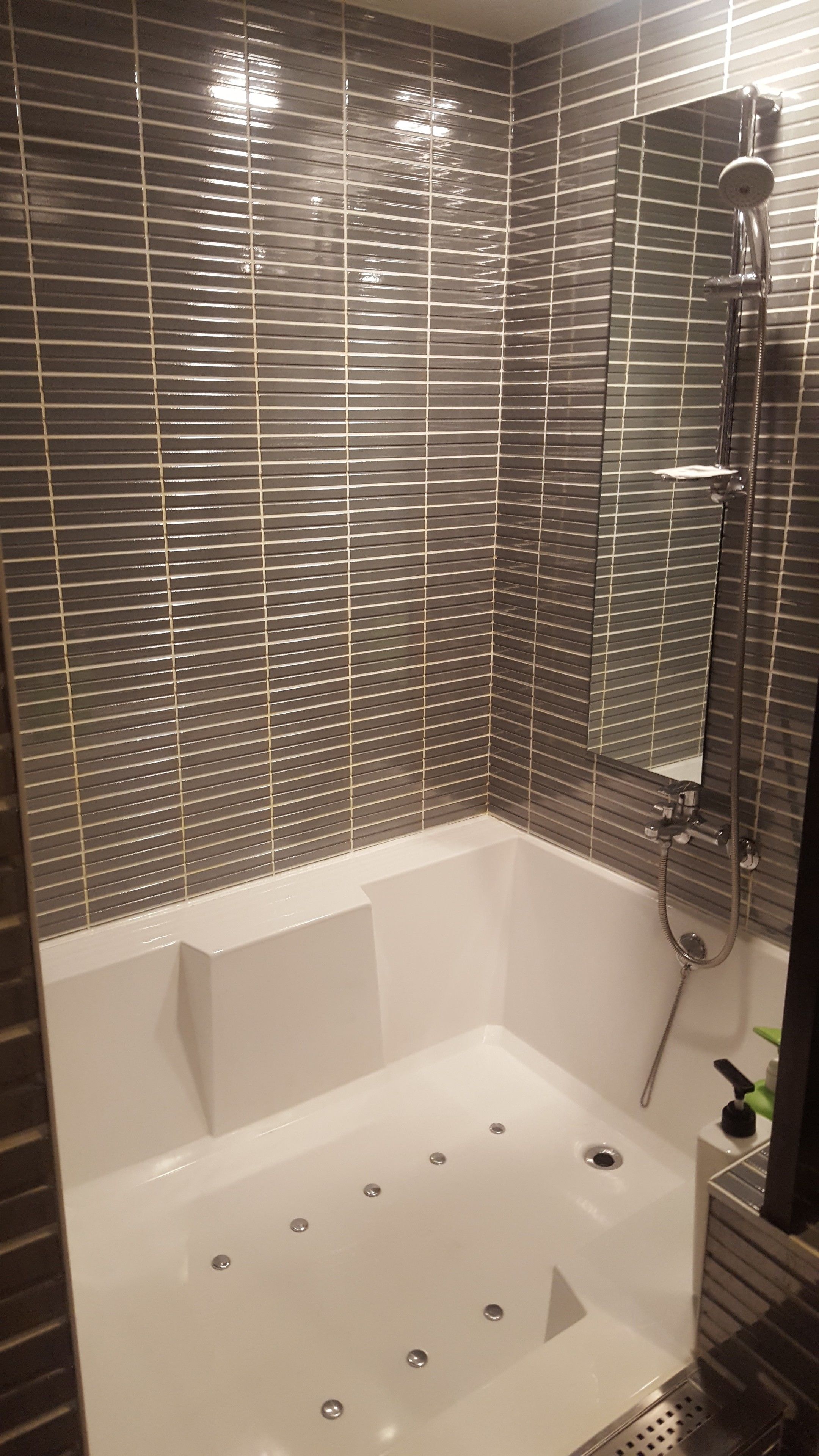 Un baño moderno con bañera, ducha y espejo.