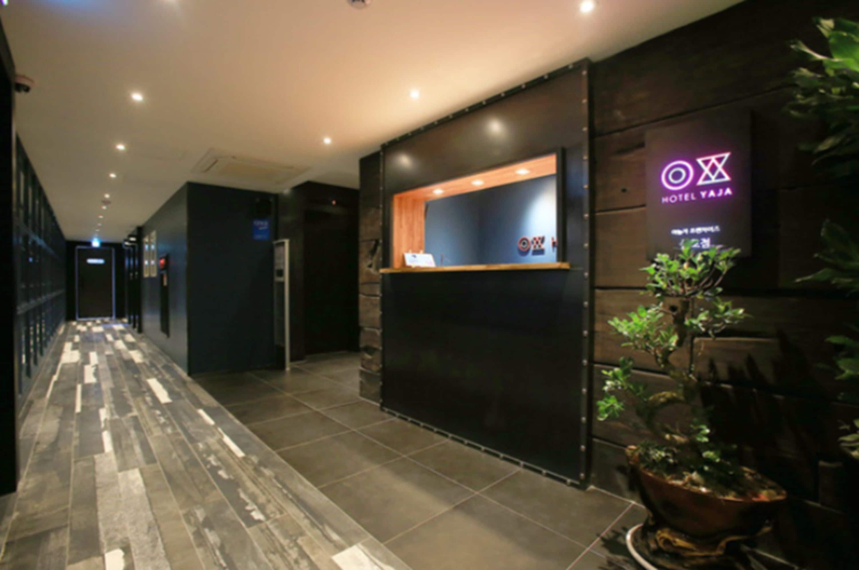 En hotellobby med modern design, inklusive en receptionsdisk och en neonskylt.