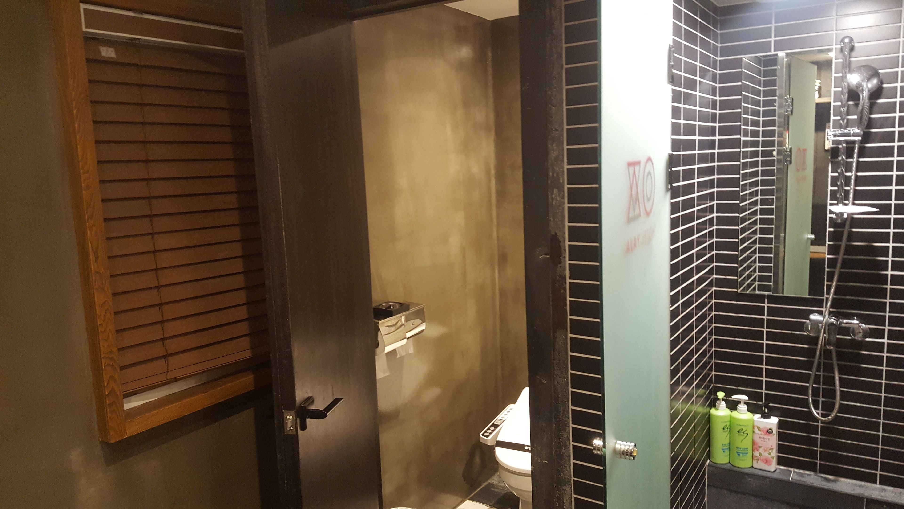 A bathroom with a toilet, a shower, and a sink.