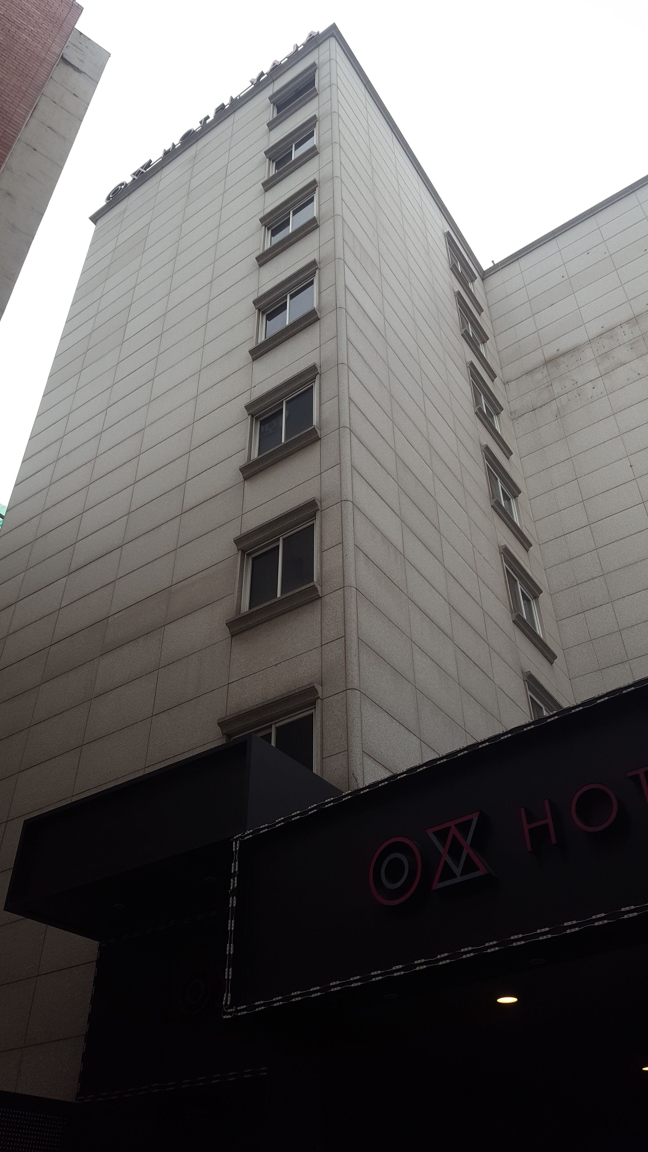 A tall hotel building with a sign reading "OX HOTEL" at the bottom.