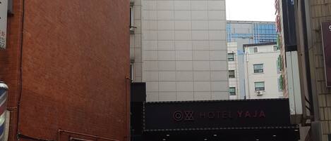 Entrada de un hotel con un letrero que dice "Hotel Yaja" y flechas direccionales en el pavimento.