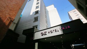 A hotel sign with the name "HOTEL YAJA" and a modern building in the background. - Hotel Yaja Jongno (Seoul)