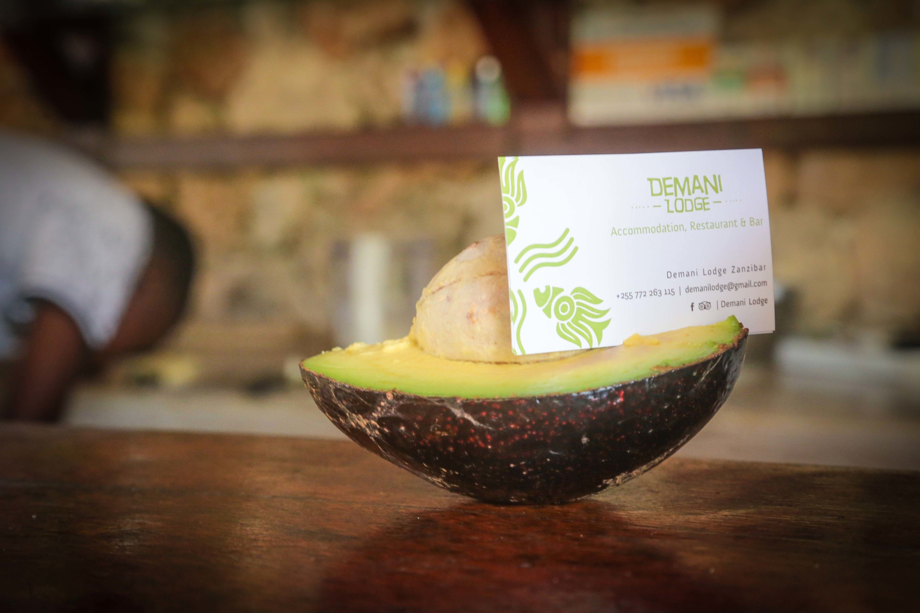 A bowl of avocado with a business card on top.