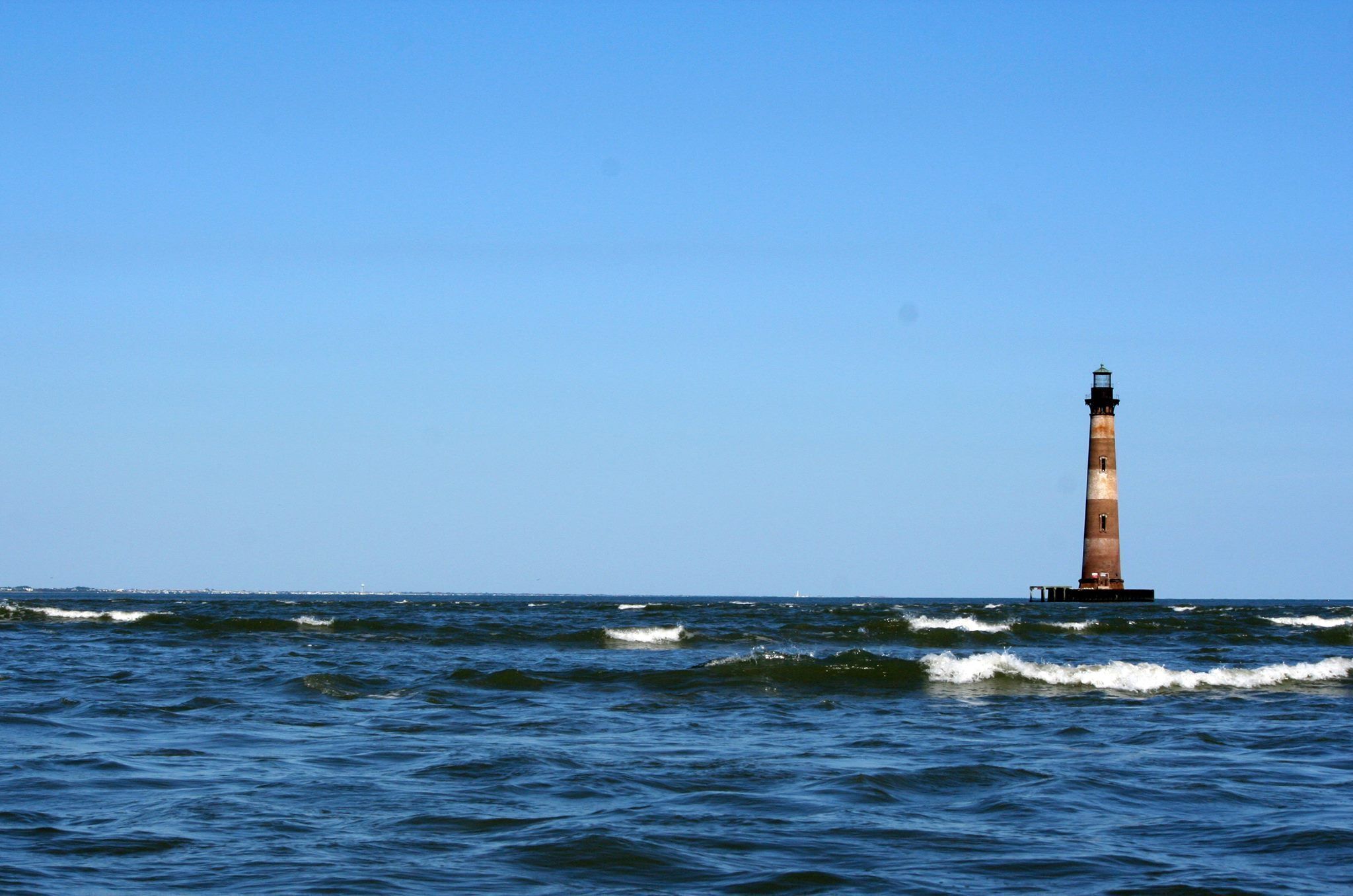 Un phare situé sur un promontoire rocheux en pleine mer.