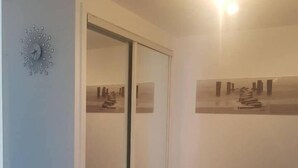 Une pièce dotée d’une porte-fenêtre coulissante, d’une horloge murale et d’un tableau encadré.