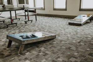 Une pièce avec un tapis à motifs, une table avec des chaises et un banc avec des coussins.