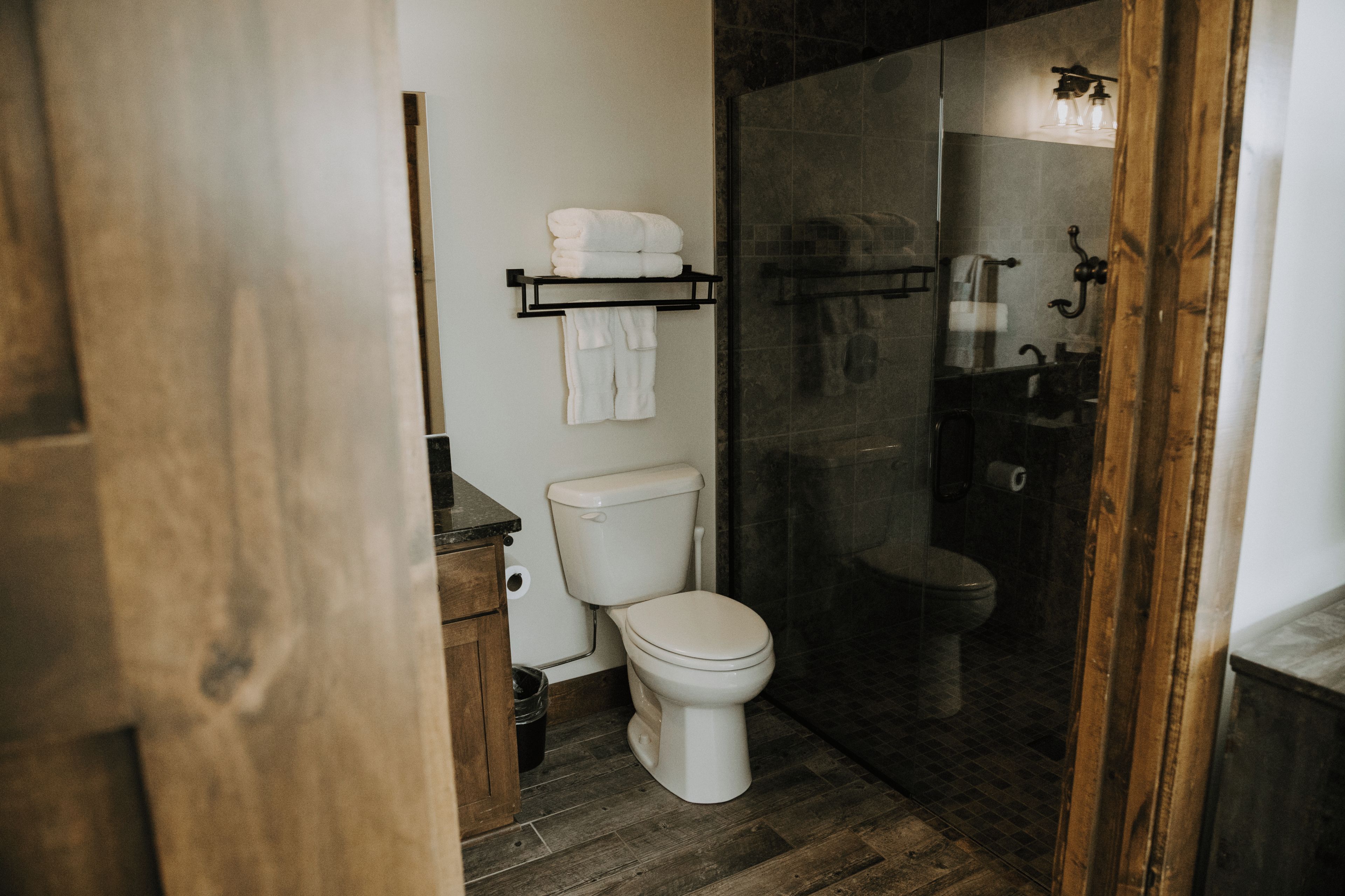 Ein Badezimmer mit Toilette, Duschkabine und Handtuchhalter.