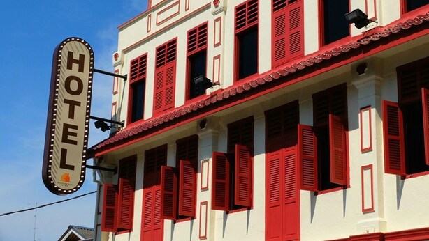 A hotel building with a prominent sign reading "HOTEL" and red window shutters. - Streetview Hotel (Muar)