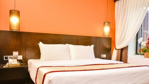 A hotel room with a large bed, two bedside lamps, a nightstand with a phone, and a window with curtains. - Streetview Hotel (Muar)