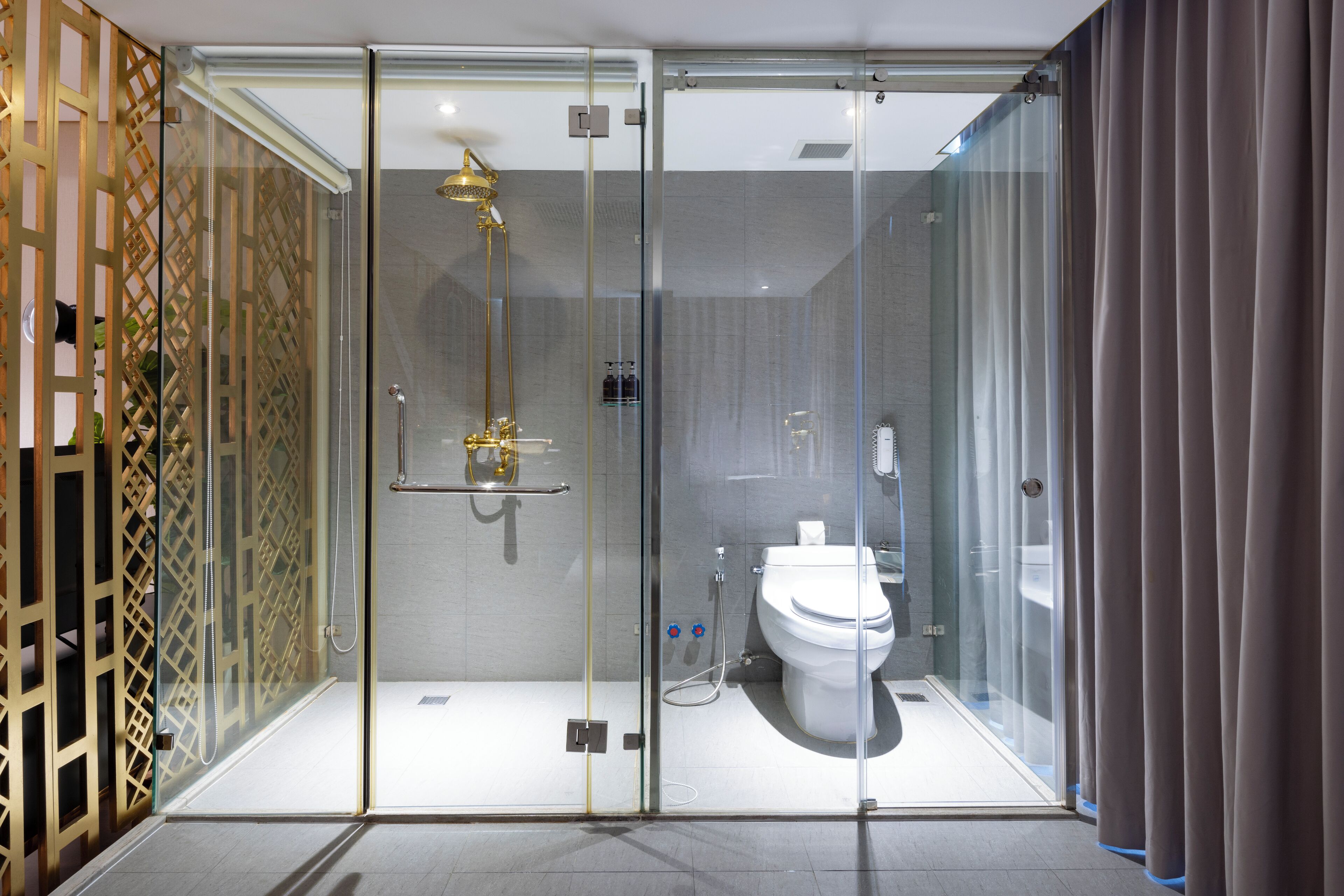A modern bathroom with a glass-enclosed shower, a toilet, and a sink.