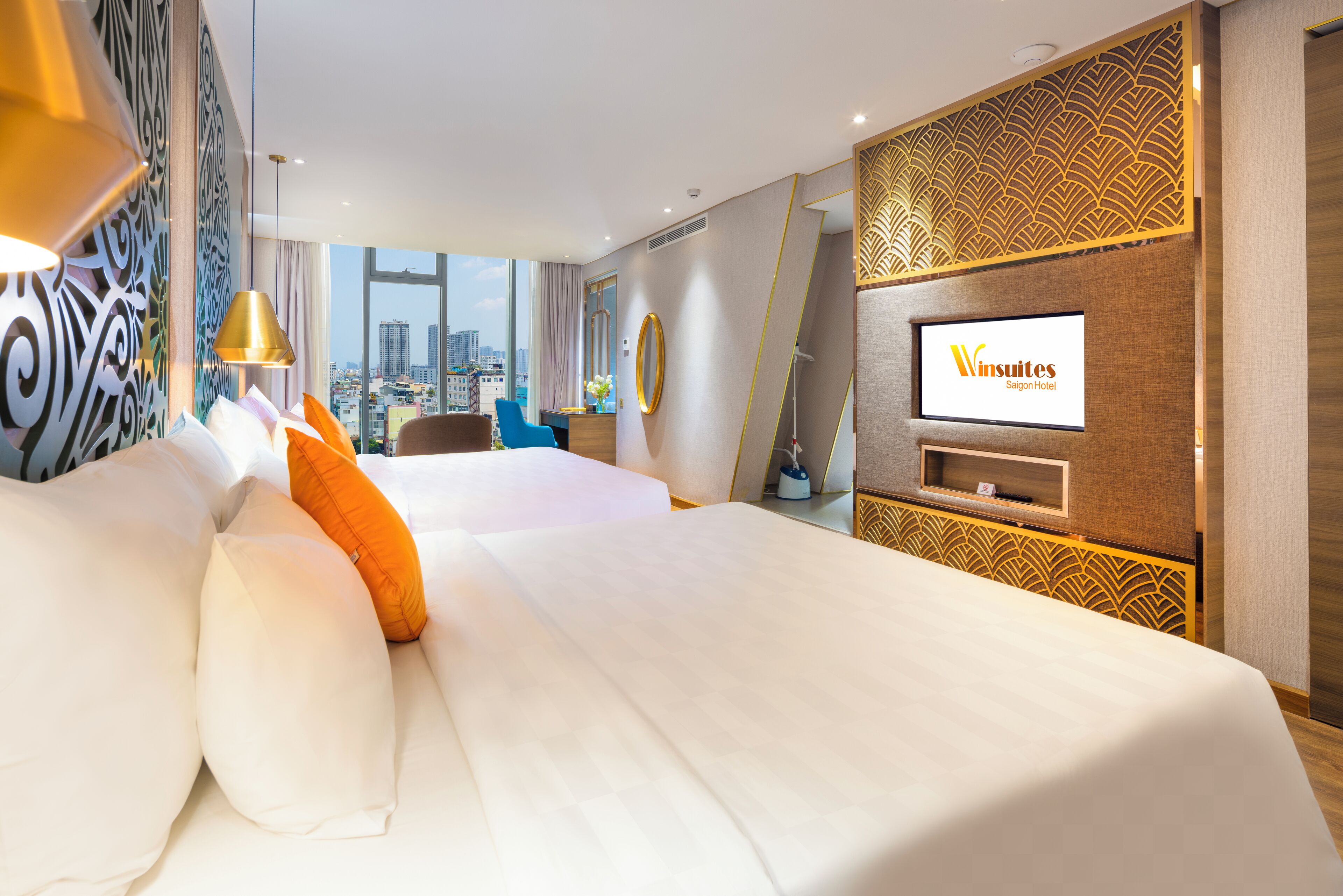 A modern hotel room with a large bed, a TV, and a city view.