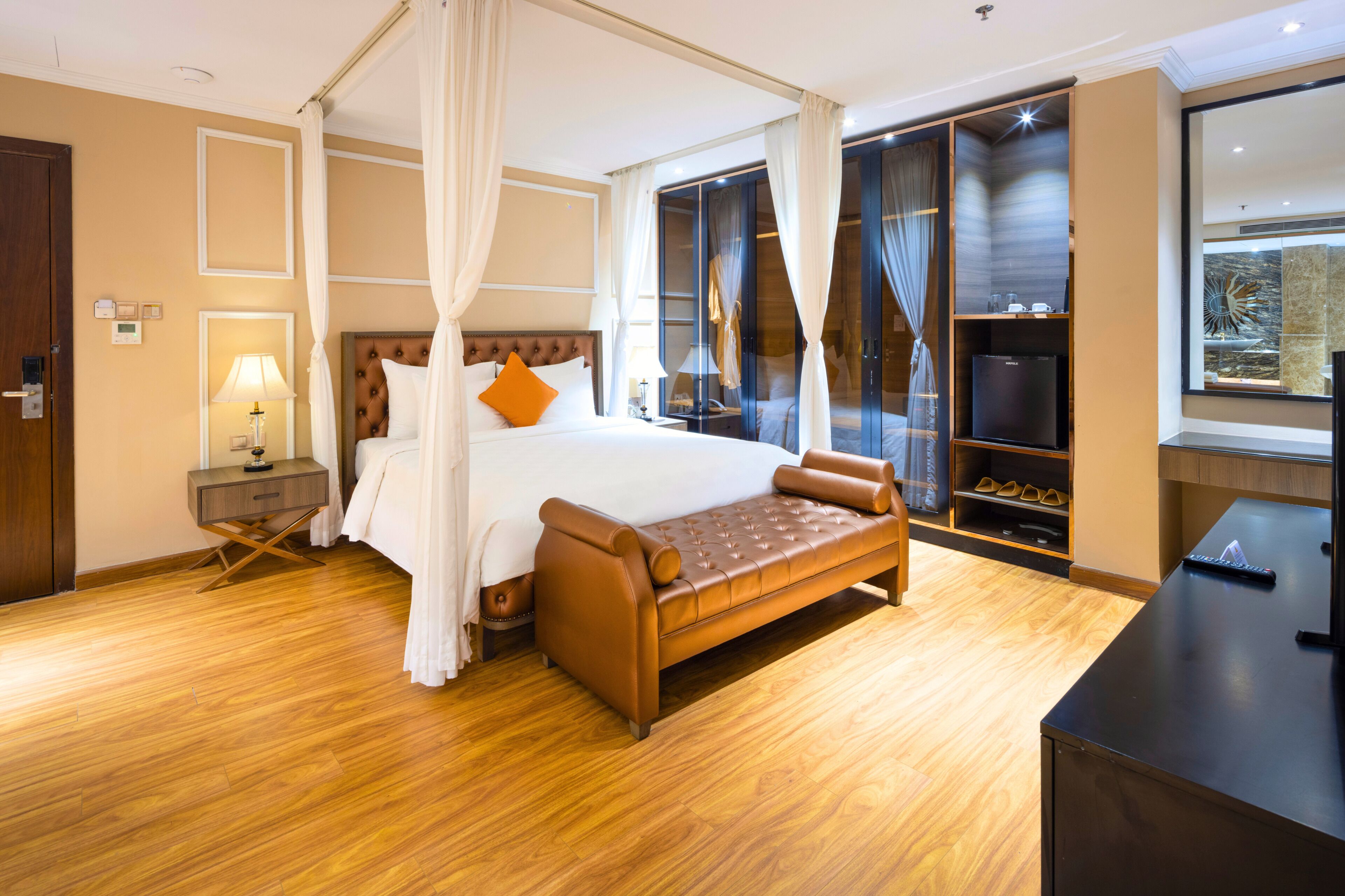 Un dormitorio amplio con una cama grande, zona de estar, televisor y armario.