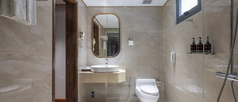 A modern bathroom with a glass-enclosed shower, a built-in sink, and a toilet.