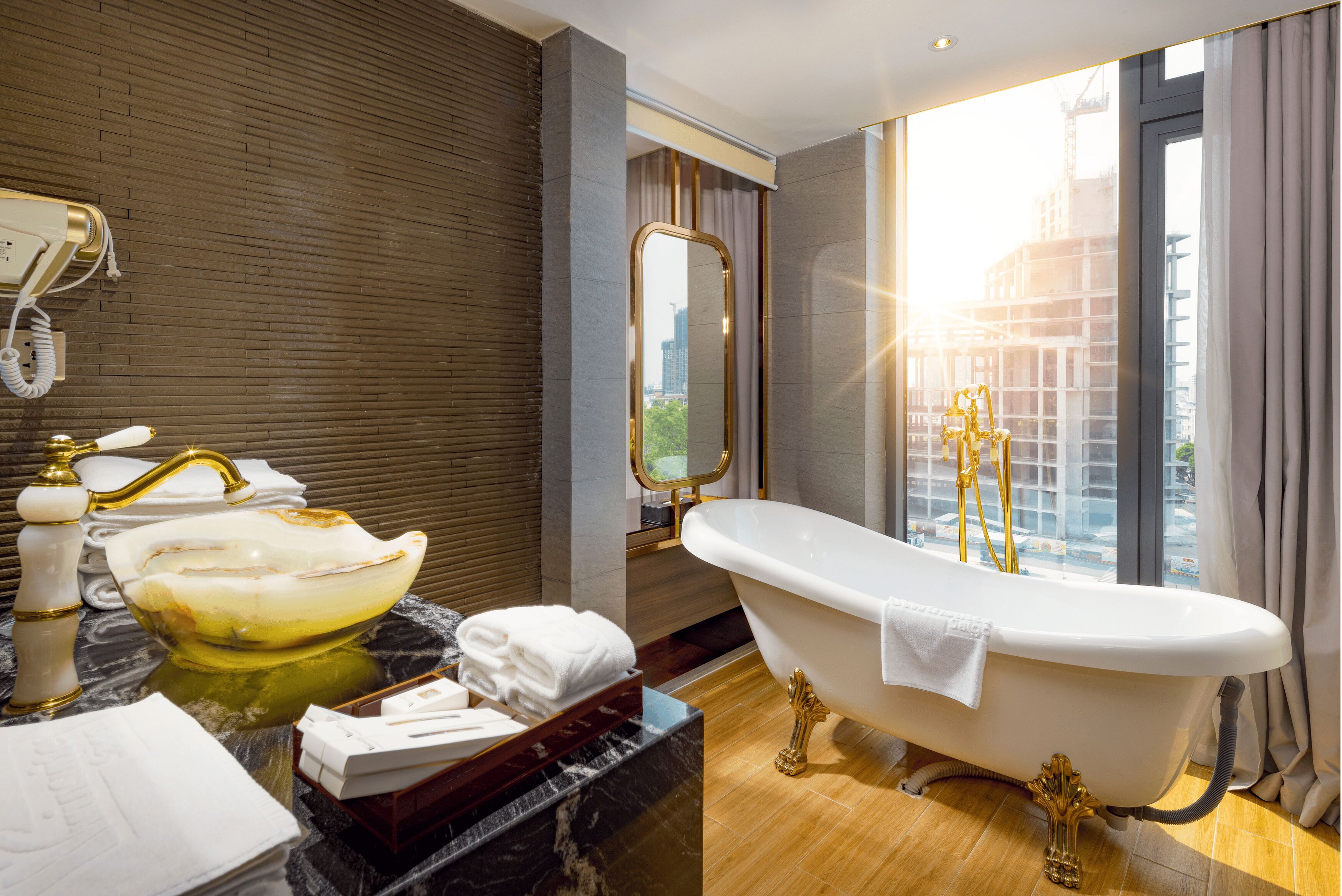 A modern bathroom with a freestanding bathtub, a large mirror, and a view of a cityscape through a large window.