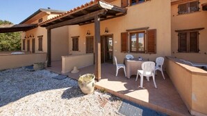 A building with a patio area featuring outdoor seating and a small pool. - Al Castelluccio (Monteverdi Marittimo)