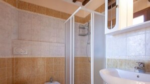 A bathroom with a shower enclosure, a bidet, and a sink. - Al Castelluccio (Monteverdi Marittimo)