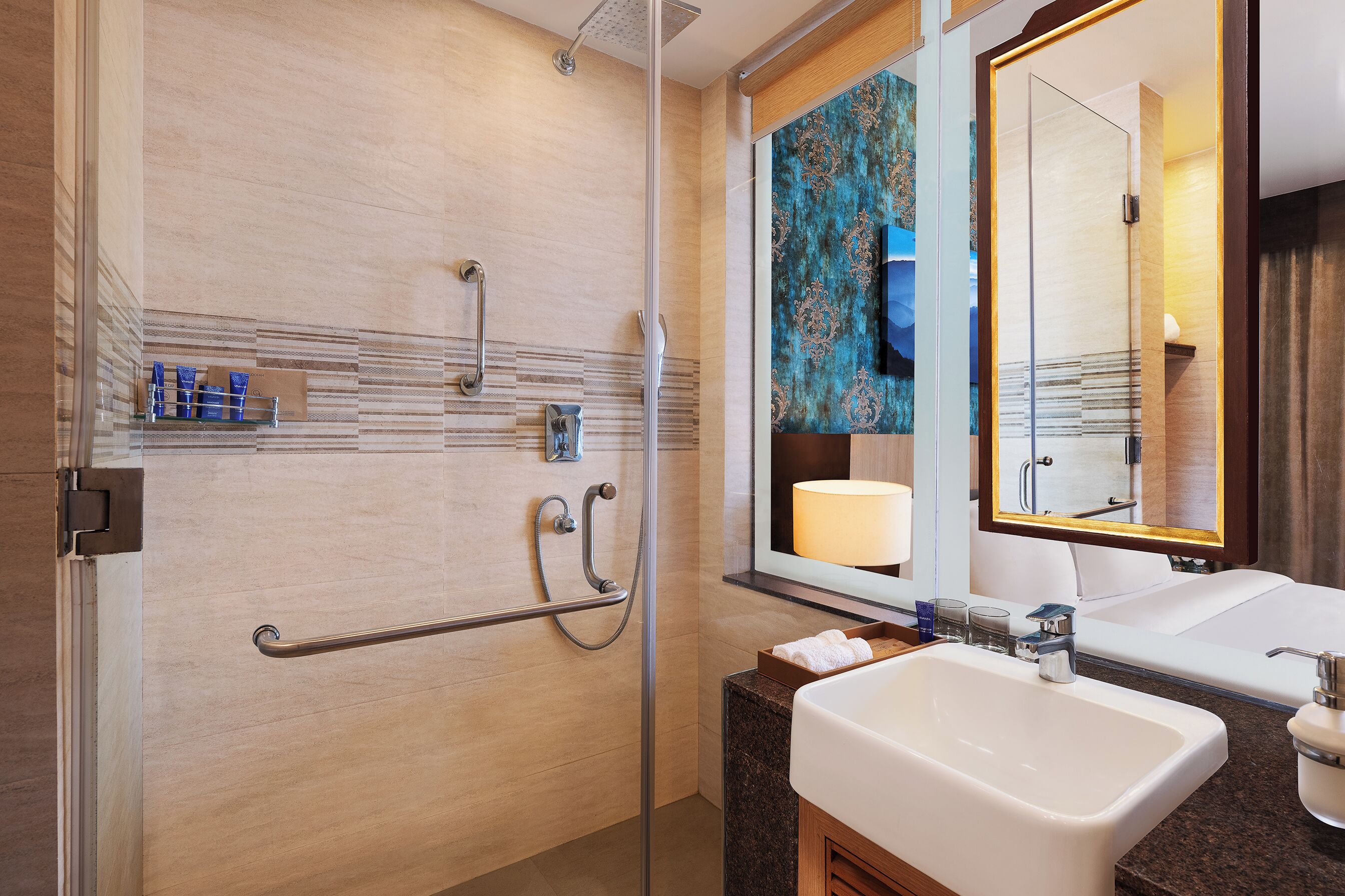 Une salle de bain moderne avec une douche, un lavabo et un miroir.