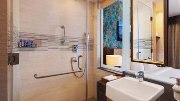 Un baño moderno con ducha, lavabo y espejo.