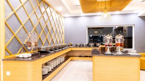 Una barra de desayuno moderna con diseño de madera, un expositor de vidrio y diversas opciones de comida y bebida.