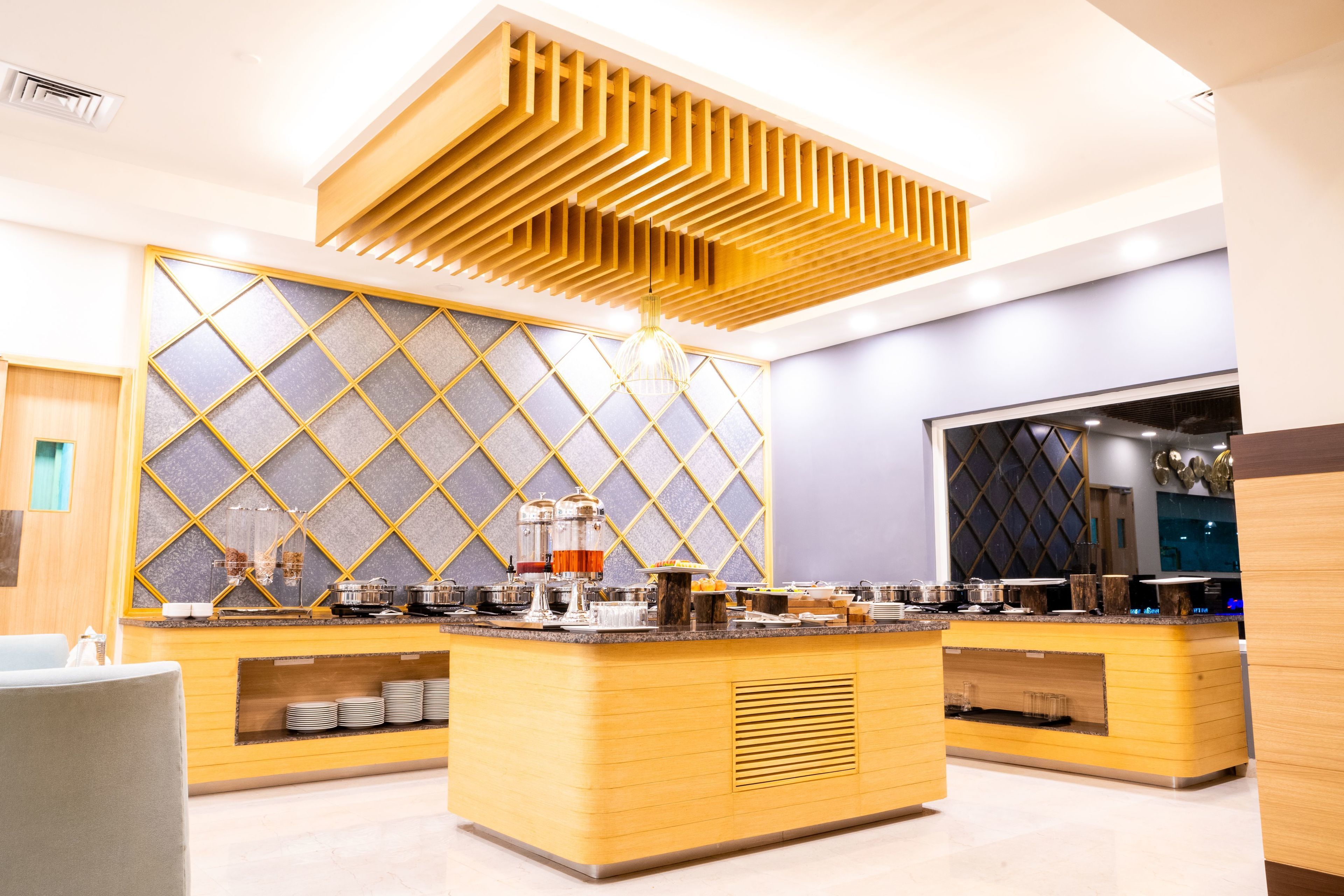 Una cocina moderna con encimeras de madera, una isla central y un panel decorativo en el techo.