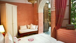 A bedroom with a bed, a sofa, a wardrobe, and a window with curtains. - Riad Al Loune (Marrakech)