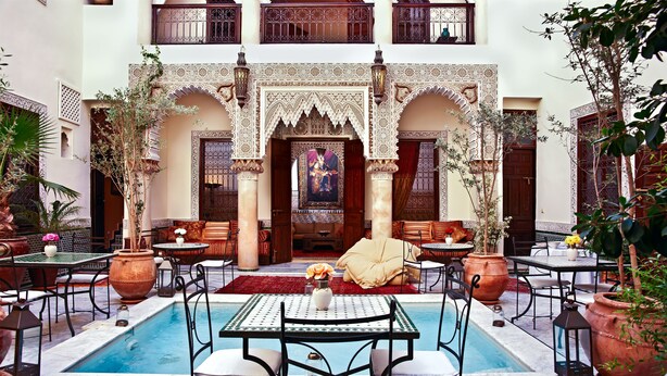 A courtyard with a pool, outdoor seating, and decorative arches. - Riad Al Loune (Marrakech)