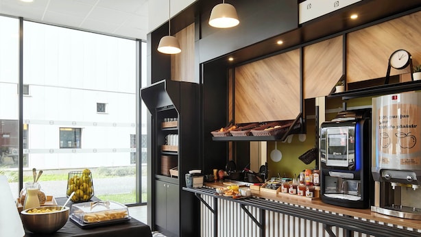 Una cocina moderna con cafetera, frutera y mesa de buffet con alimentos.