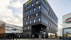 Un hotel moderno con fachada negra, varios pisos y un llamativo letrero que dice 'HOTEL'.