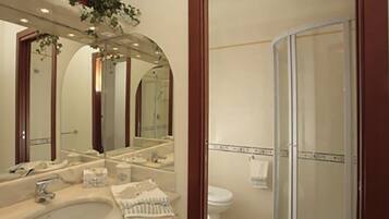 Un baño con lavamanos, espejo y ducha.