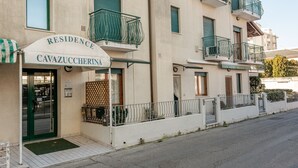 A building with a sign reading "Residence Cavazuccherina" and balconies with green railings. - Residence Cava Zuccherina (Jesolo)