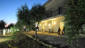 Un edificio con balcón y zona de estar al aire libre al anochecer.