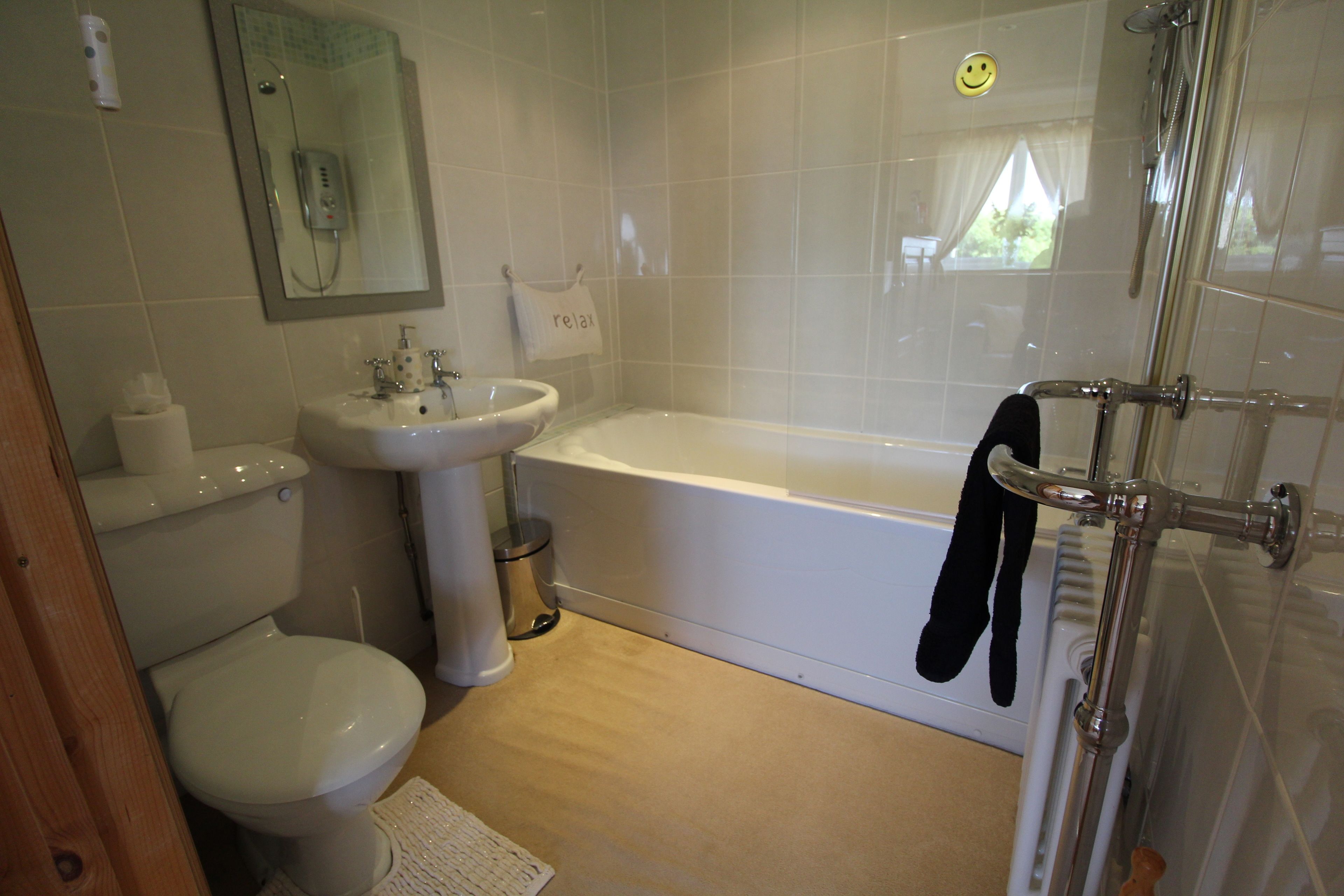 A bathroom with a toilet, sink, and bathtub.
