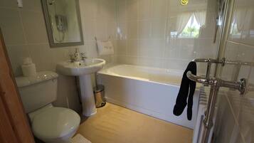 A bathroom with a toilet, sink, and bathtub.