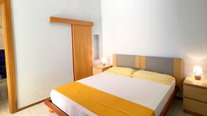 A bedroom with a bed, bedside tables, a wardrobe, and a nightstand.
