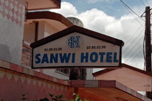 Une enseigne pour l’hôtel Sanwi, avec le nom de l’hôtel et une date.