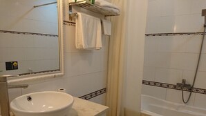 A bathroom with a sink, mirror, towel rack, shower, and bathtub. - Classic Room- Free Laundry Services in District 1 (District 1)