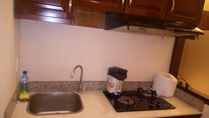 A kitchen with a sink, stove, and cabinets. - Classic Room- Free Laundry Services in District 1 (District 1)