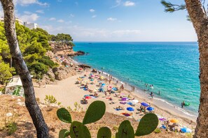 Une plage avec des gens, des parasols et une mer bleue et limpide.