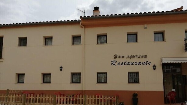 Ein Gebäude mit einer Fassade, auf der das Schild „AQUILAR Restaurante“ steht.