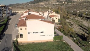 Un edificio con un letrero que dice "H* AGUILAR" y "CARNES A LA BRASA".