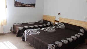 Ein Schlafzimmer mit zwei Betten, jeweils mit Kopfstütze und einem Nachttisch aus Holz.