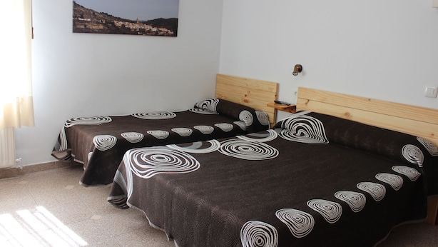 Un dormitorio con dos camas, cada una con cabecera y mesita de noche de madera.