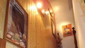 Un interior de madera con una escalera de mármol, un cartel en la pared y un cuadro enmarcado sobre la escalera.