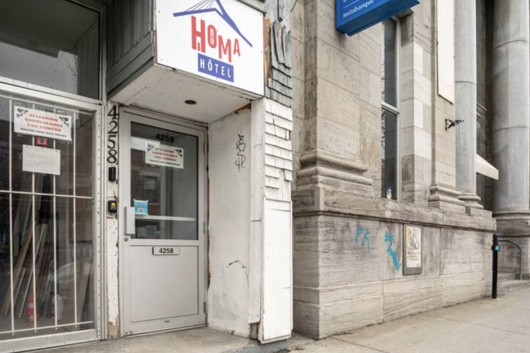 A hotel entrance with a sign reading "Homa Hotel" and a door marked with the number 4258.