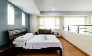 Une chambre d’hôtel avec un lit, une chaise, une fenêtre et un balcon.