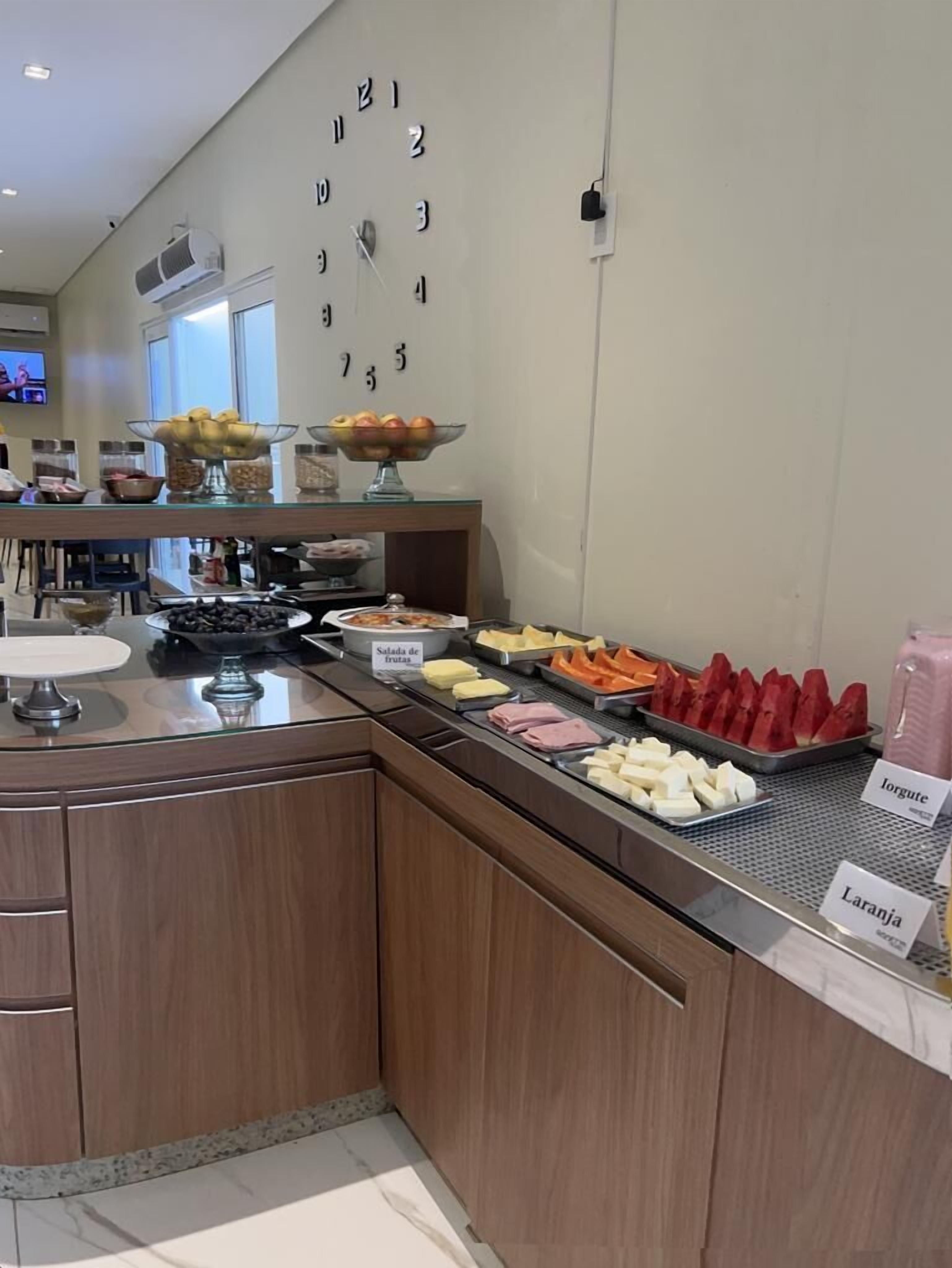 A buffet area with various food items and a wall clock.