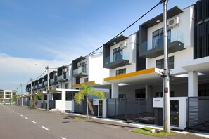 Stylish building with flat roof, large windows, and balconies with glass railings.